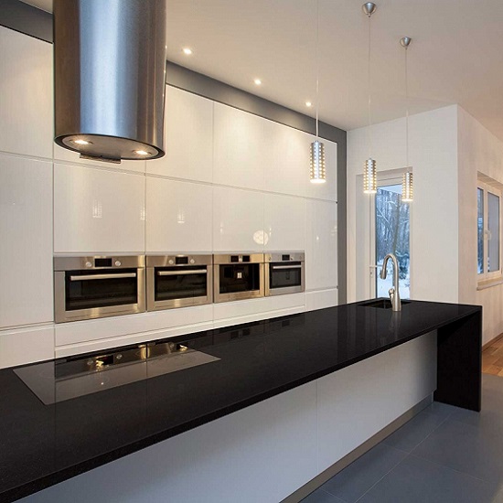 A modern kitchen with white cabinets, a hob, and steel extractor
