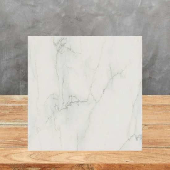 A Caesarstone Snowdrift sample on wooden floor and grey background