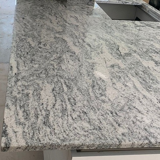 A kitchen island installation in London made from Cosmic White Granite