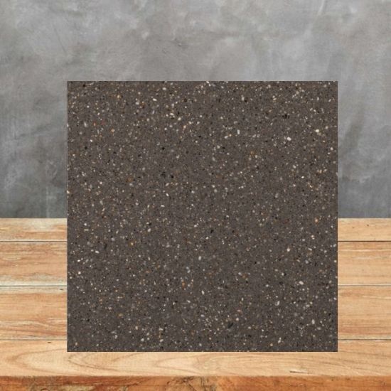 a sample of Quartzforms Pebble Dark Grey quartz with a grey wall behind