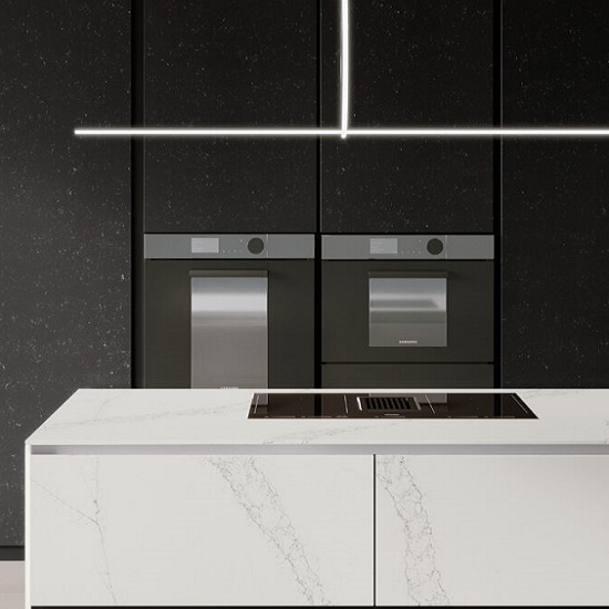 a kitchen island in Quartzforms Ocean Arctic with black cabinets and appliances