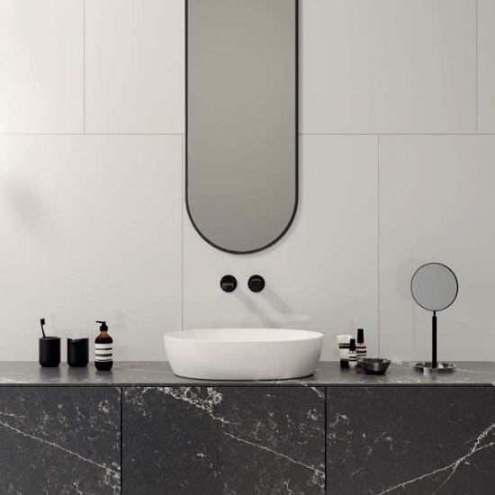 A bathroom vanity in Quartzforms Ocean Midnight quartz, a mirror and a white wall