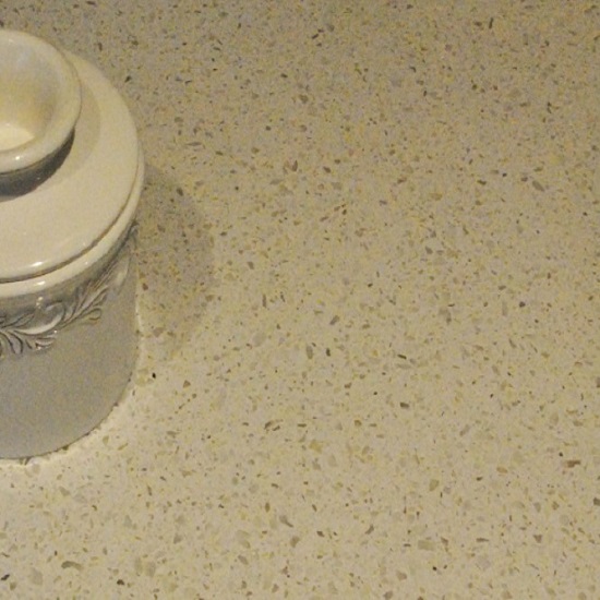 a Quartzforms Pebble Cappuccino quartz worktop with a white vase