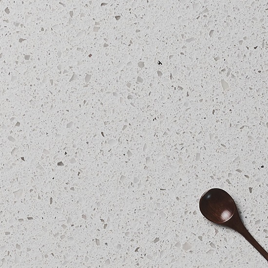 A a worktop in Quartzforms Brazilian Canadian White matt finish quartz worktop with a spoon on it