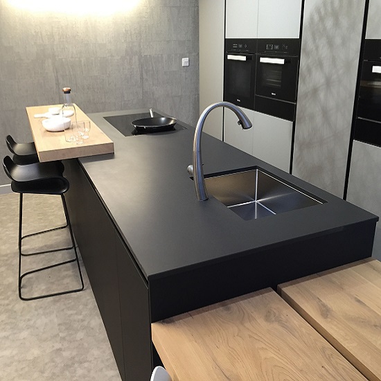 a photo of a Quartzforms Cloudy Black worktop in a kitchen with a wooden breakfast bar