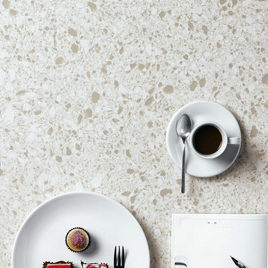 a Quartzforms Imperial Meringa worktop, a coffee cup and plate on it