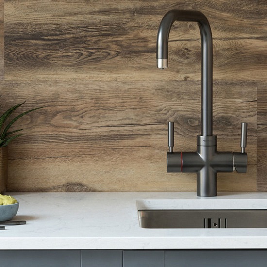 a CRL Vicenza worktop with a sink cut out, a steel tap and a wooden wall behind