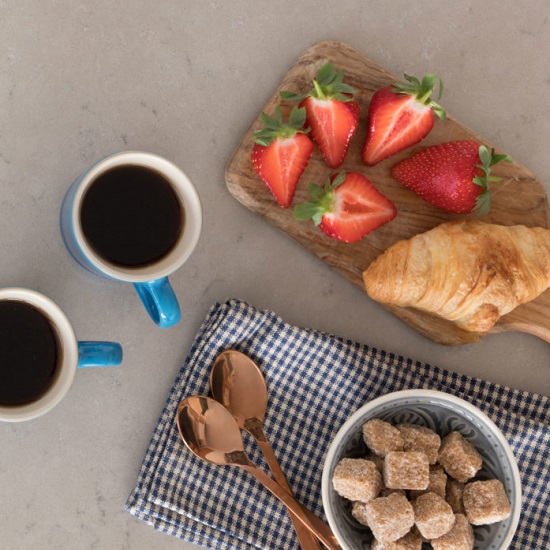 a worktop in CRL Quartz Antico with pastries and coffee on it