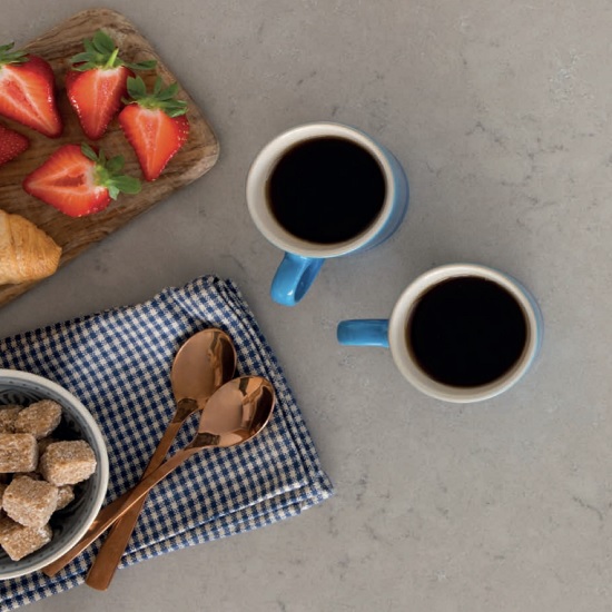 a CRL Quartz Antico countertop, two coffee cups, sugar cubes, and strawberries