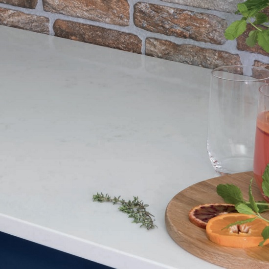a kitchen with exposed brickwork and CRL Quartz Carrara countertops