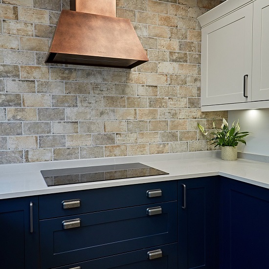 a modern kitchen with CRL Quartz Firenze countertops, blue cabinets and a bronze coloured hood