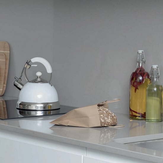 a splashback and 20mm thick CRL Quartz Soft Concrete worktops with bottles and a white kettle