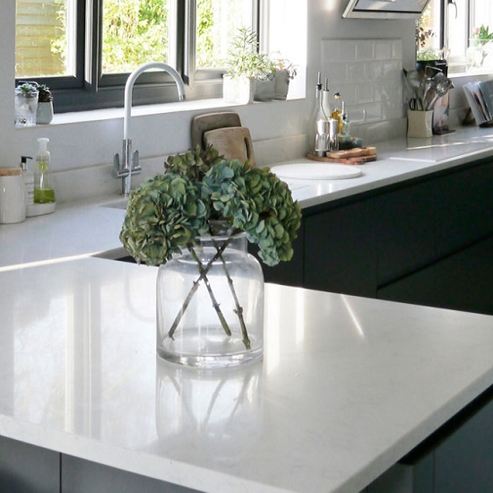 a polished CRL Quartz Verona worktop in a modern kitchen with big windows
