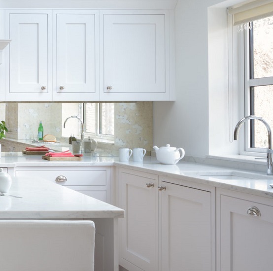 a white kitchen with an island and worktops in CRL Quartz Verona
