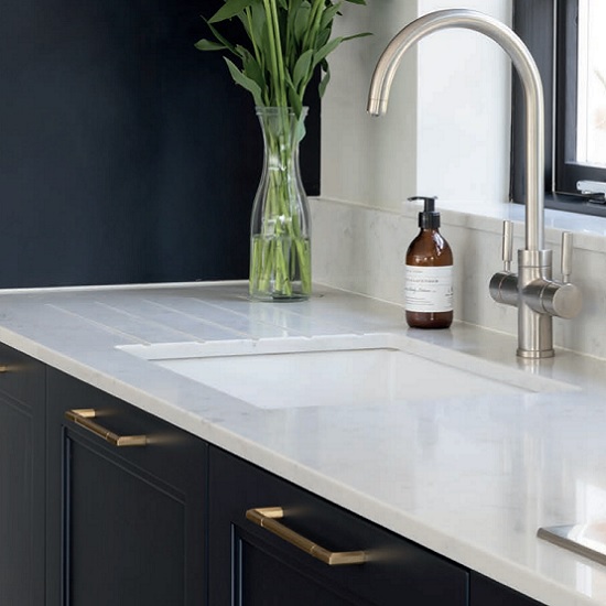 a sink run of a CRL Quartz Verona worktop with a tap, a soap bottle and a plant pot