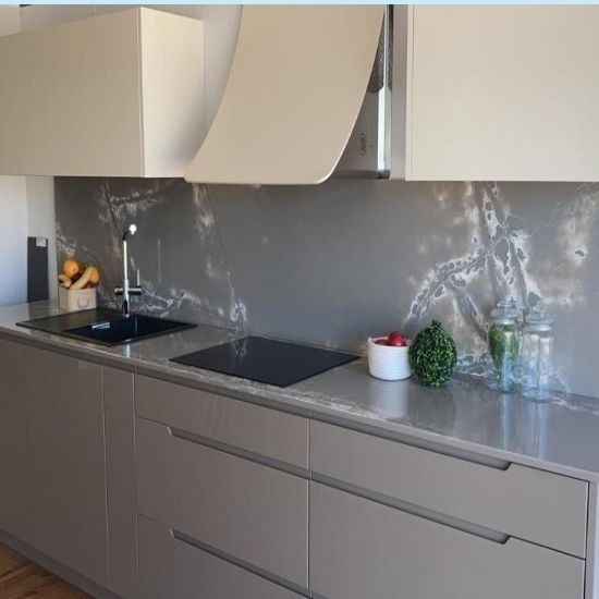 a kitchen with Compac Ice White quartz splashback and worktops