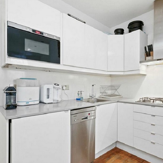a photo of a white kitchen with Compac Ceniza worktops from The Worktop Library in London