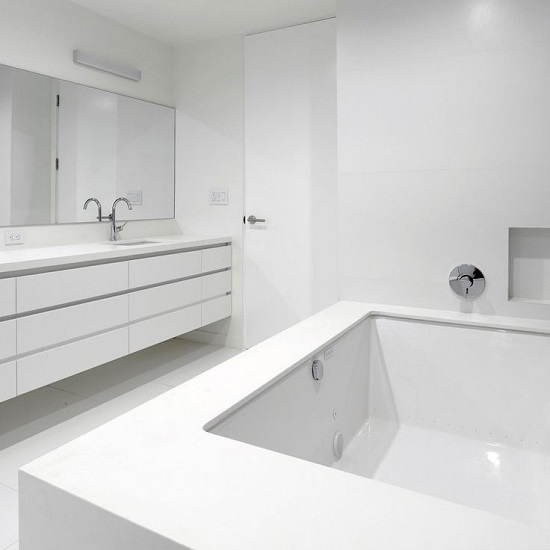 a bathroom worktop and bath surround in Compac Absolute Blanc quartz