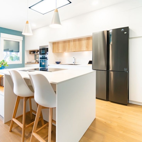 a modern kitchen with an Compac Absolute Blanc island worktop