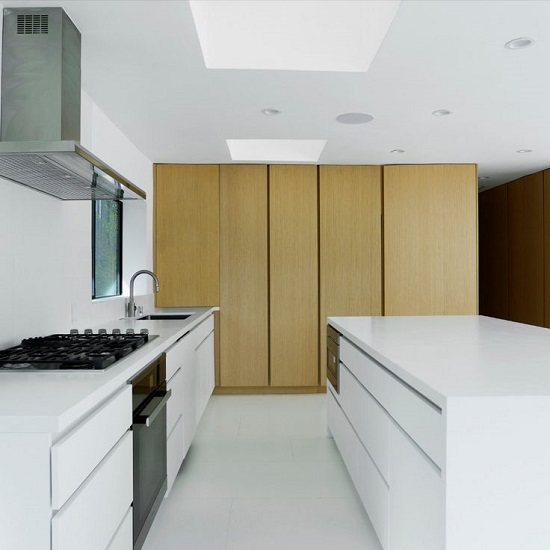 a kitchen with worktops and island in Compac Absolute Blanc quartz