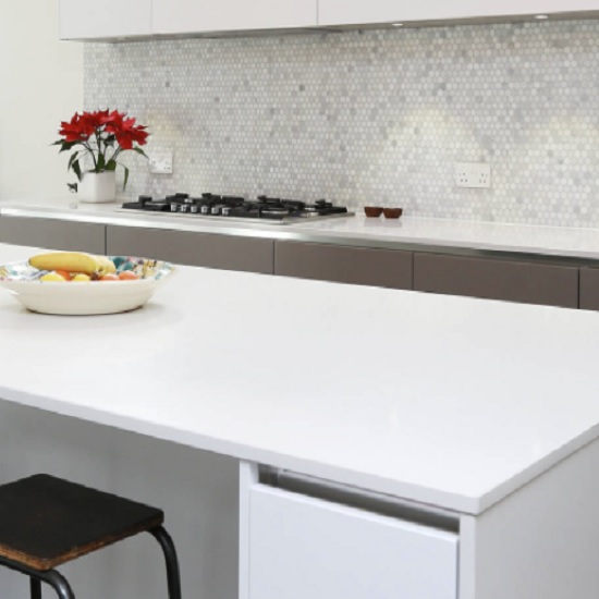 a photo of a white kitchen with Compac Glaciar worktops and island