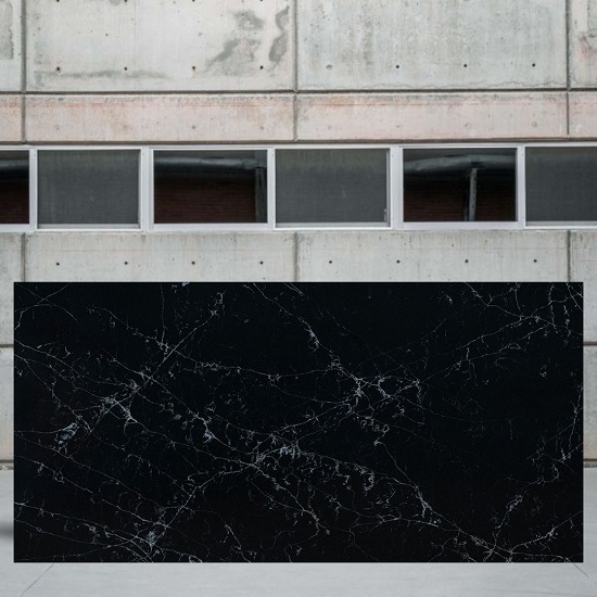 an image of a Compac Unique Portoro quartz slab and a cement wall behind