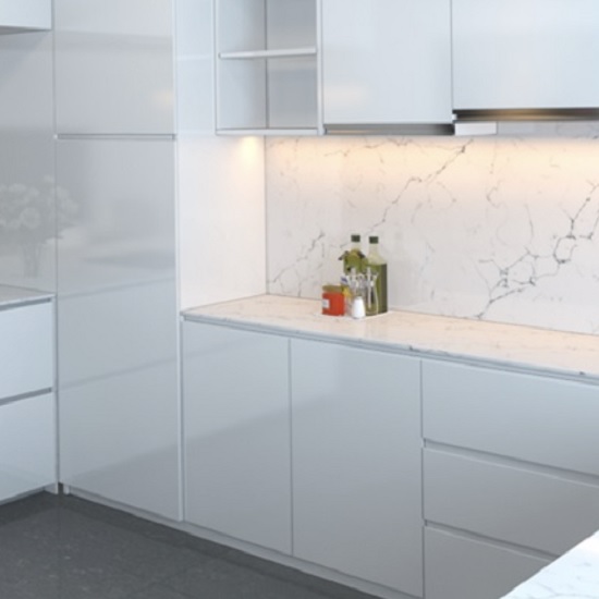 a photo of a white kitchen with Unistone Carrara Venatino polished worktops and walls