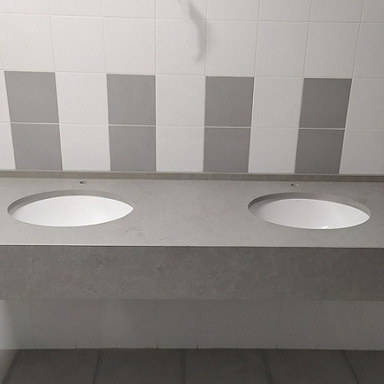 a Unistone Concreto vanity top in a bathroom and two white sinks