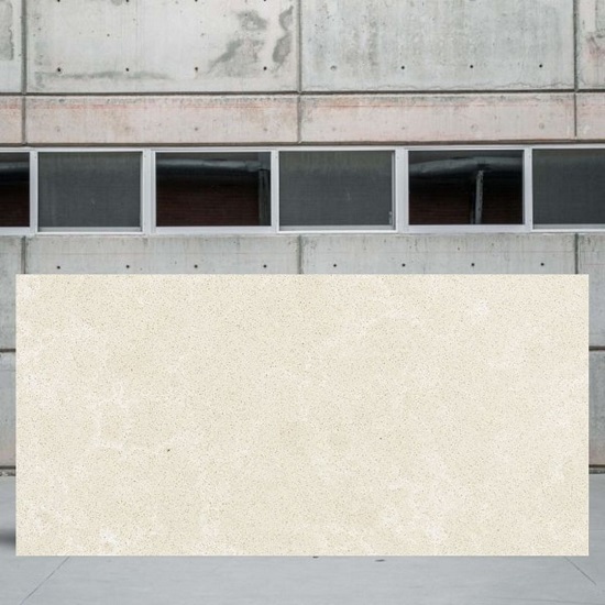 an image of a Unistone Crema Marfil quartz slab for worktops and a cement wall behind