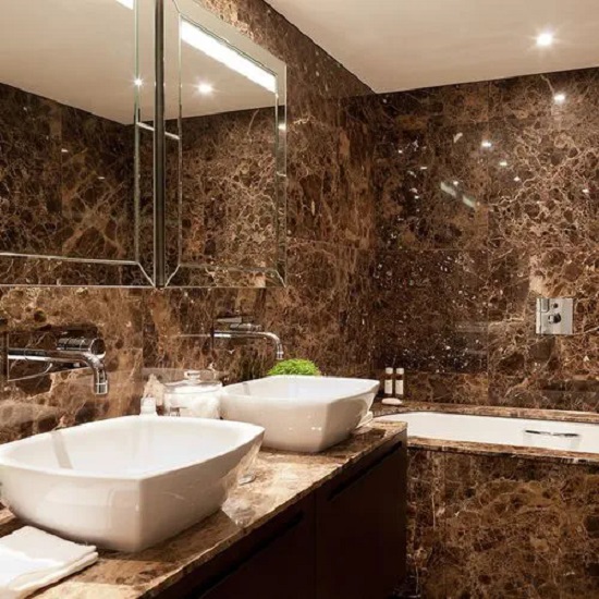 a bathroom with Emperador Brown marble vanity tops, walls, and floors