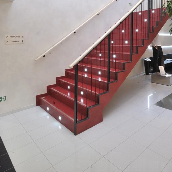 Technistone Starlight White floor tiles and red stairs