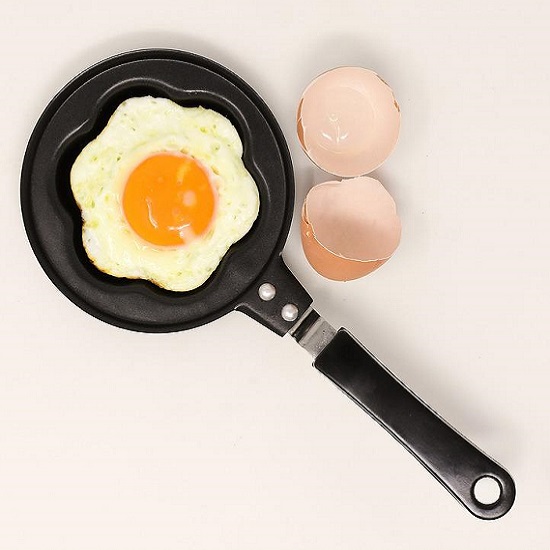 a bird's eye view of a Nile Quartz Cristal White worktop and a frying pan with eggs