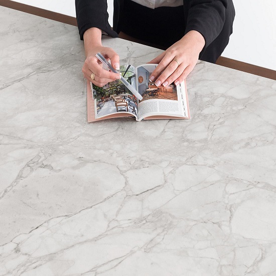 a worktop in Xtone Porto Grey natural finish with a person reading a magazine