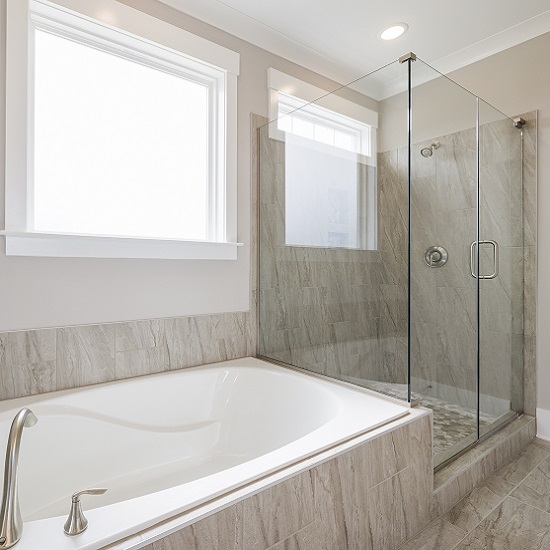 a photo of a bathroom with Fantasy Brown Marble walls and bath tub cladding