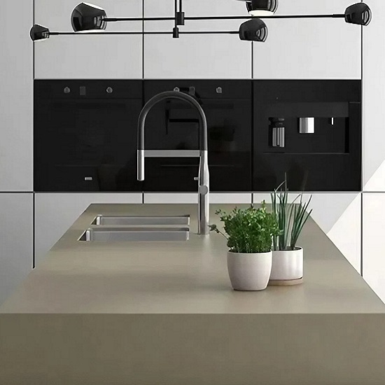 a photo of a white kitchen with Arklam Agora Vison worktops, a silver faucet, two vases with plants and a black backsplash