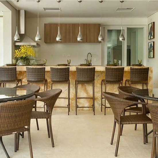 a photo of a modern kitchen with a Cappuccino Onyx island waterfall and chairs in front