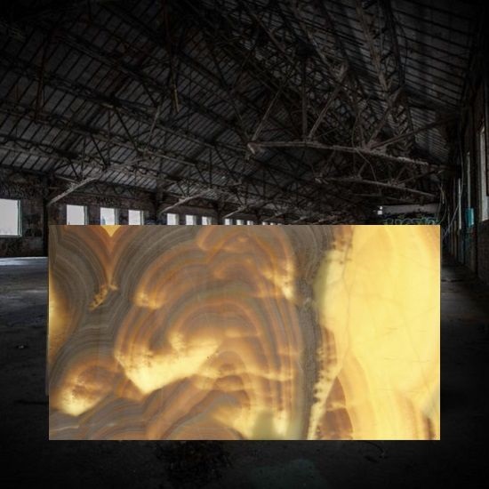 a photo of a Honey Onyx backlit slab inside a dark warehouse