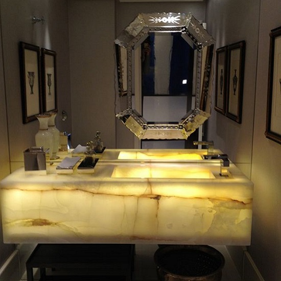 a photo of a bathroom with a Spider Onyx backlit vanity top and a silver mirror behind