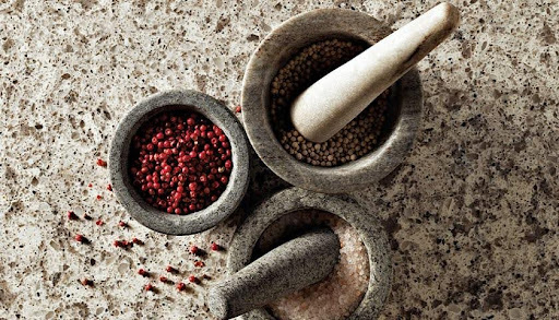 A mortar and pestle with different spices