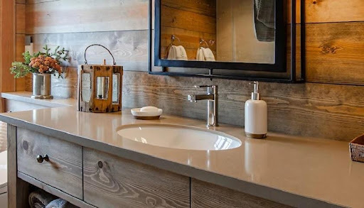 A bathroom worktop in Silestone Coral Clay and sink with a mirror and a candle holder