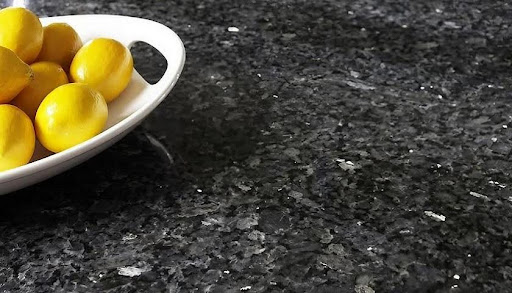A bowl of yellow tomatoes on a black counter