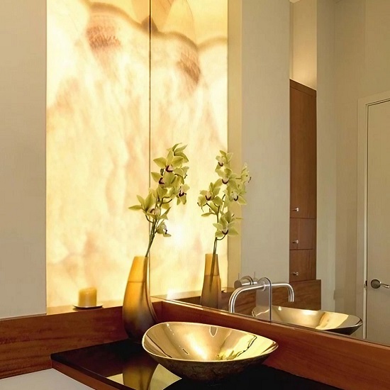 a white bathroom with Techlam Agatha Caramel wall panels and a golden basin