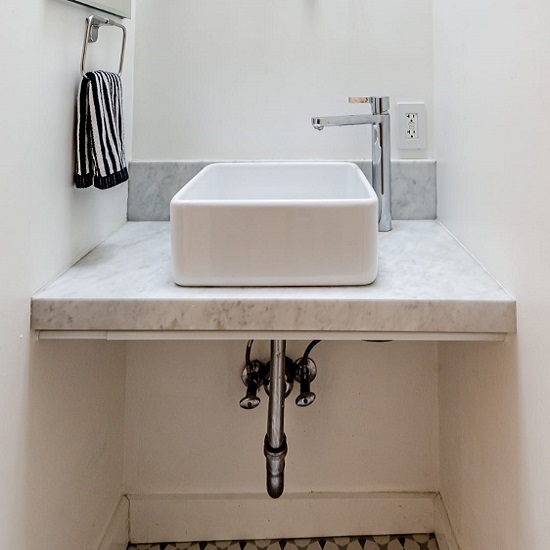 a photo of a bathroom with a Venatino marble kitchen worktop, an upstand, a tap and a towel