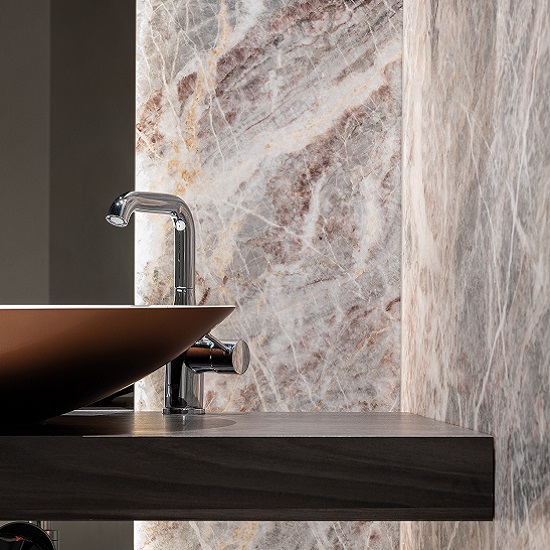 a photo of a bathroom with a Fiori Di Pesco Carnico marble wall, a vanity top and a tap