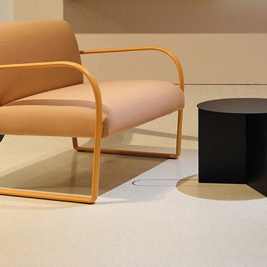 a photo showing Terrazzo Pietra Crema floor tiles, a chair, and a coffee table