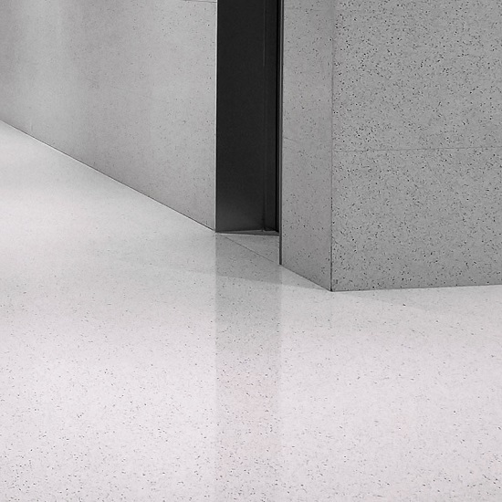 a photo of a silver terrazzo wall cladding and a white floor