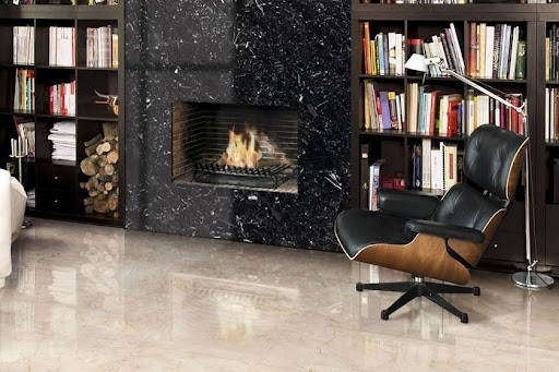 A black marble fireplace combined Crema Marfil marble floor tiles wth in a room