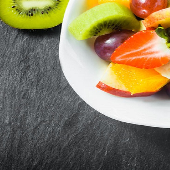 a close up of a Black Riven Slate worktop with a plate of fruit on it