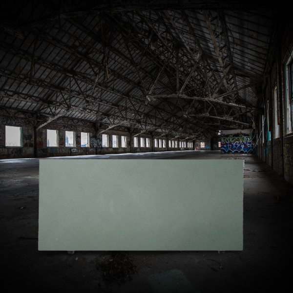 an image of a green slate slab inside a dark warehouse
