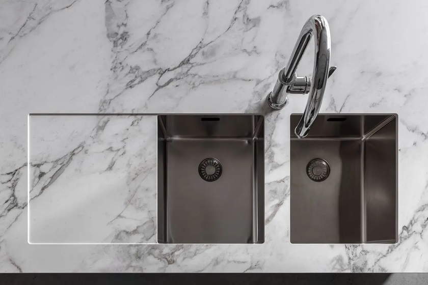 a close-up photo of a Uniceramica Arabescato Vagli worktop and a 1.5 bowl sink and chrome faucet